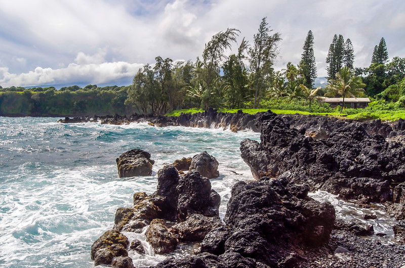 Waves crash onto jagged volcanic rock faces at Ke'anae Peninsula on the Road to Hana in Maui.